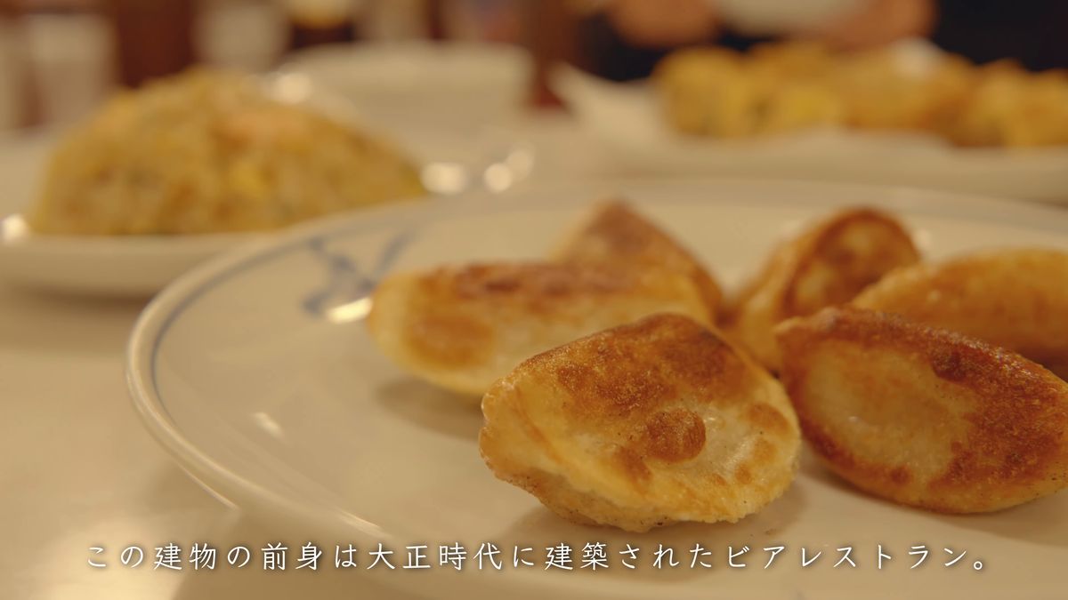 白い皿の焼き餃子と、奥の炒飯