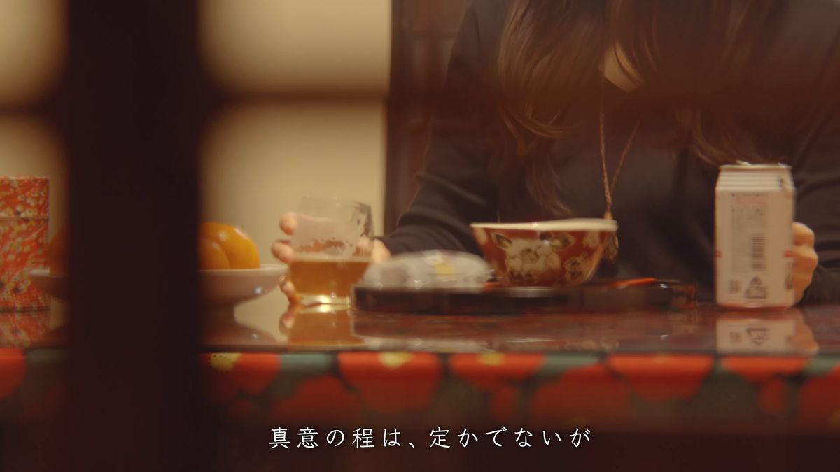 卓の上のビールのグラスと缶、茶碗とみかん