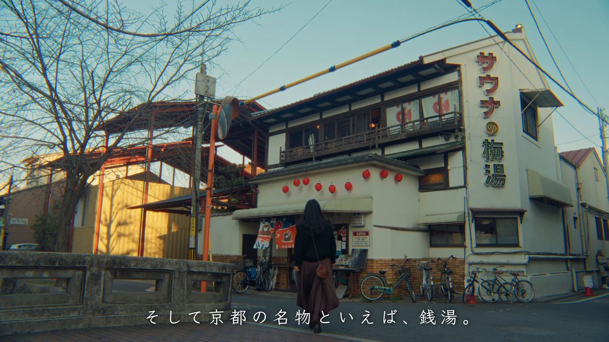 橋の向こうに建つ梅湯へ歩く後ろ姿