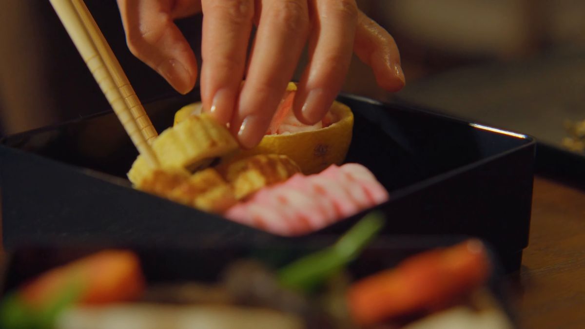 重箱に伊達巻を詰める