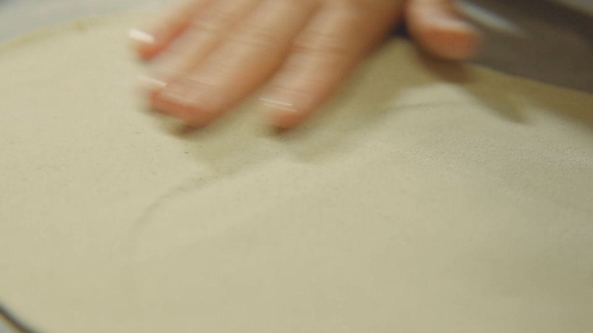 薄くのばした生地にふれる手