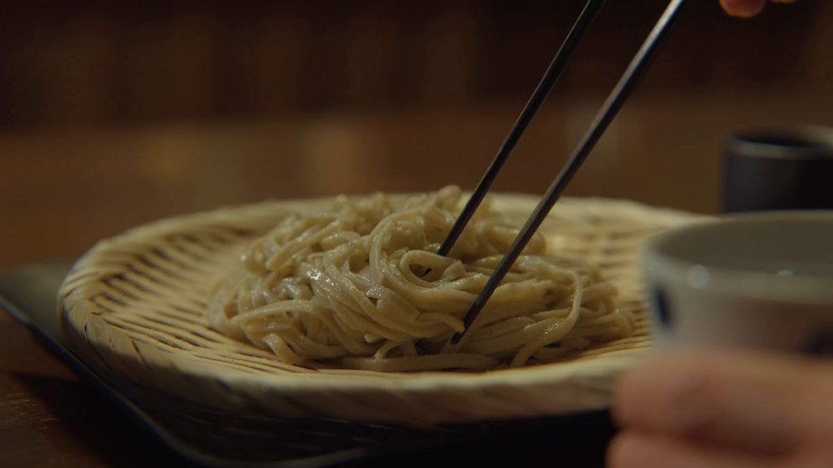ざるの蕎麦を箸で取る