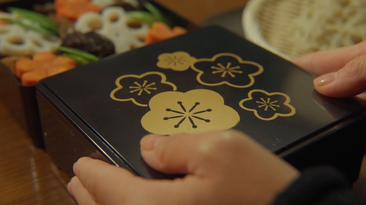 金の梅を描いた重箱の蓋を開ける