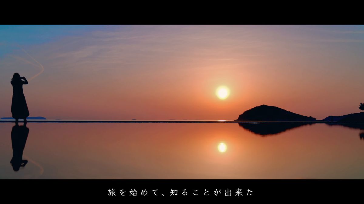 夕日を映す水鏡に立つ人影