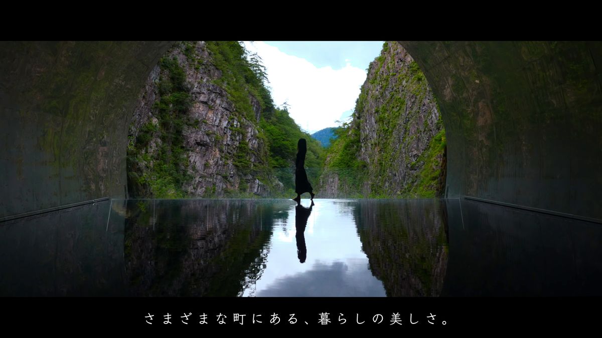 渓谷を映すトンネルの水鏡に立つ人影