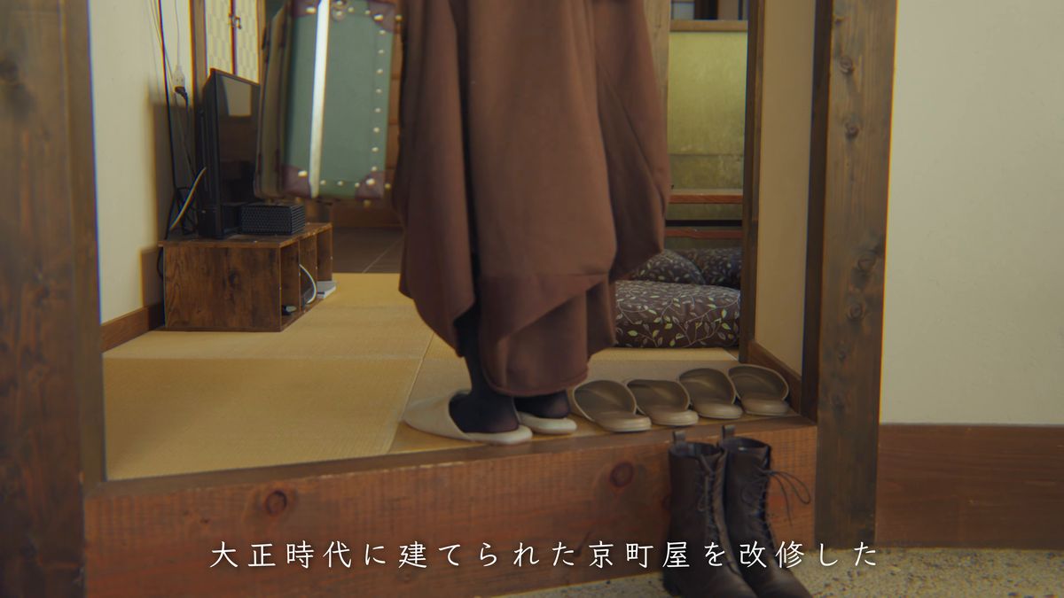 上がり框に立つ足元と、並んだスリッパ