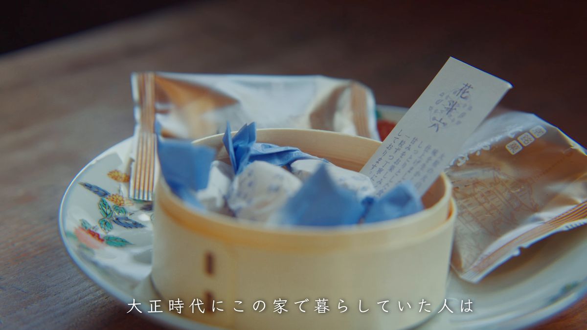曲げわっぱの器の、青い紙で包んだ菓子と札