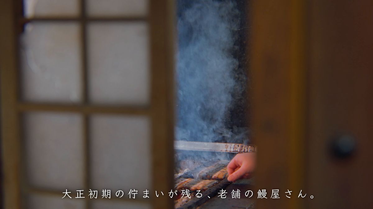 障子のすき間からのぞく、炭火で鰻を焼く手元