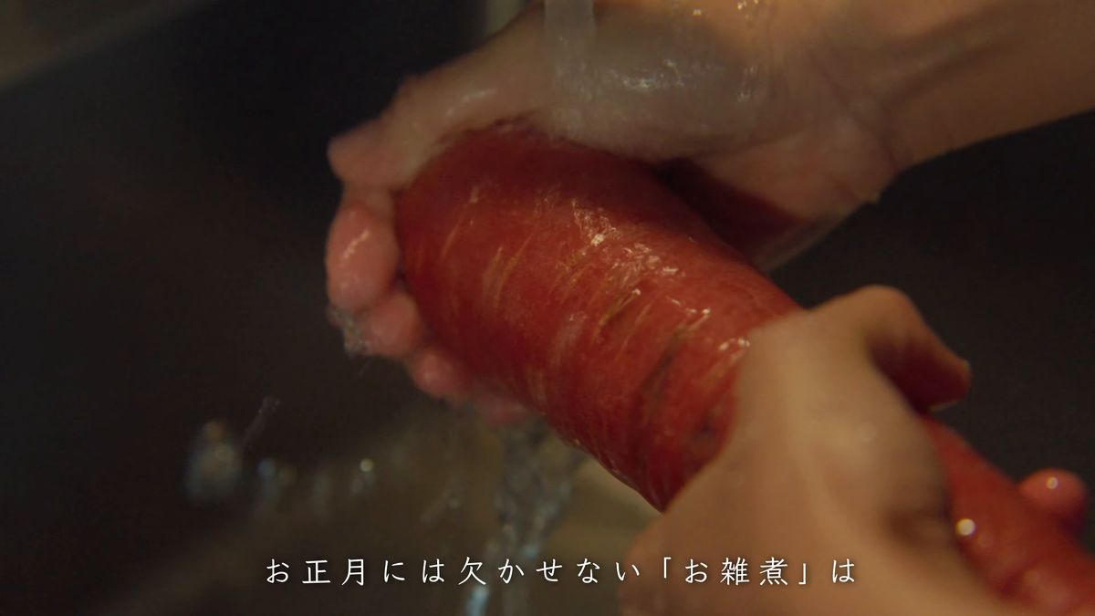 赤いにんじんを流水で洗う