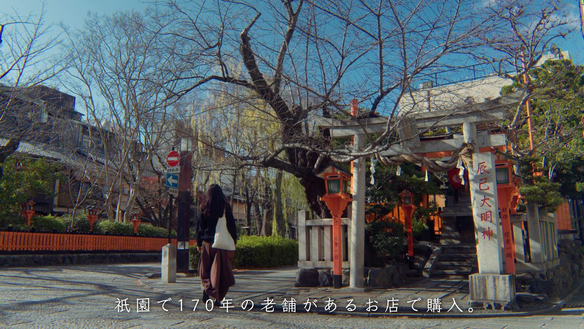 辰巳大明神の鳥居の前を歩く後ろ姿