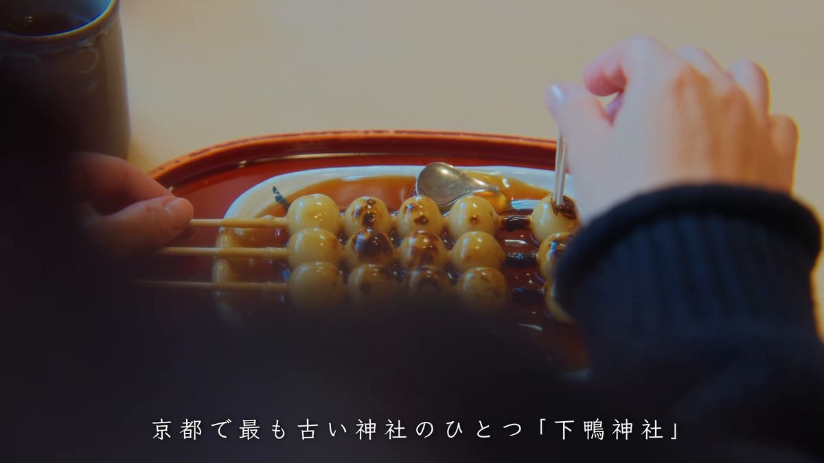 皿のみたらし団子の串を手に取る