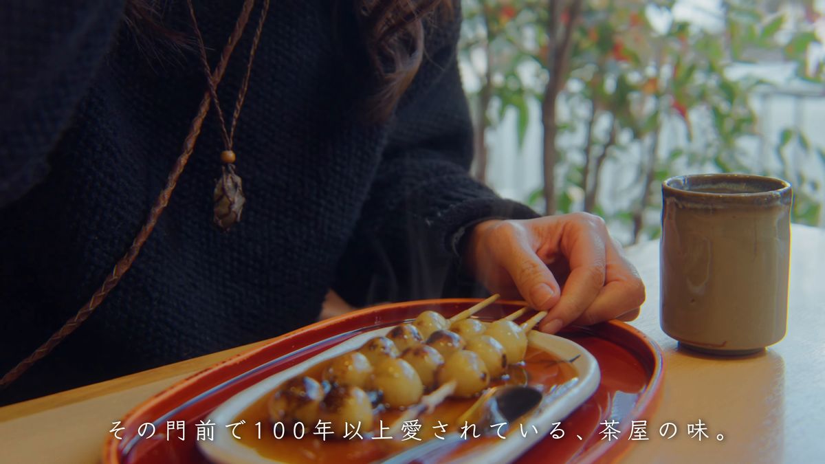 湯のみを横に、みたらし団子を食べる