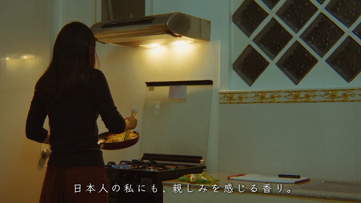 台所でフライパンを振る後ろ姿