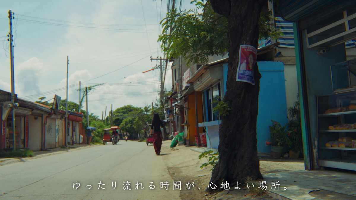 まっすぐ延びる通りを遠くへ歩く後ろ姿