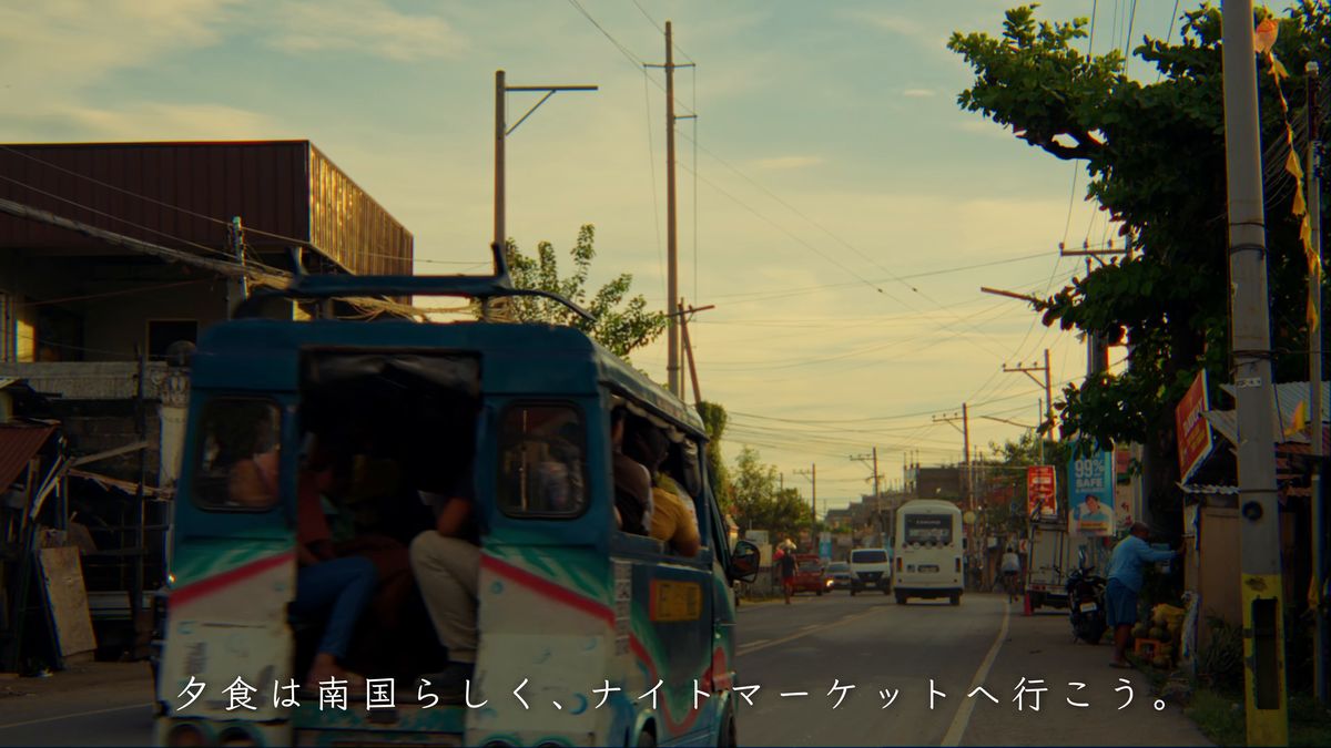 夕日に染まる通りを走るジープニー