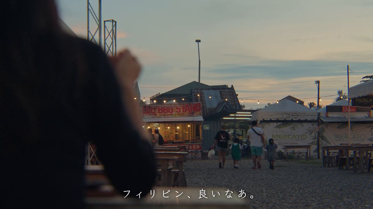 夕暮れのナイトマーケットを眺める後ろ姿