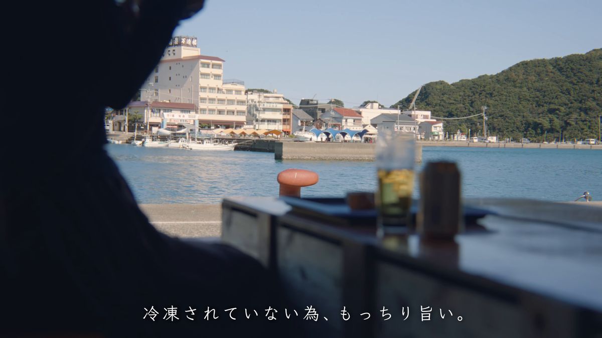 港に面したテーブルの上の丼とグラス