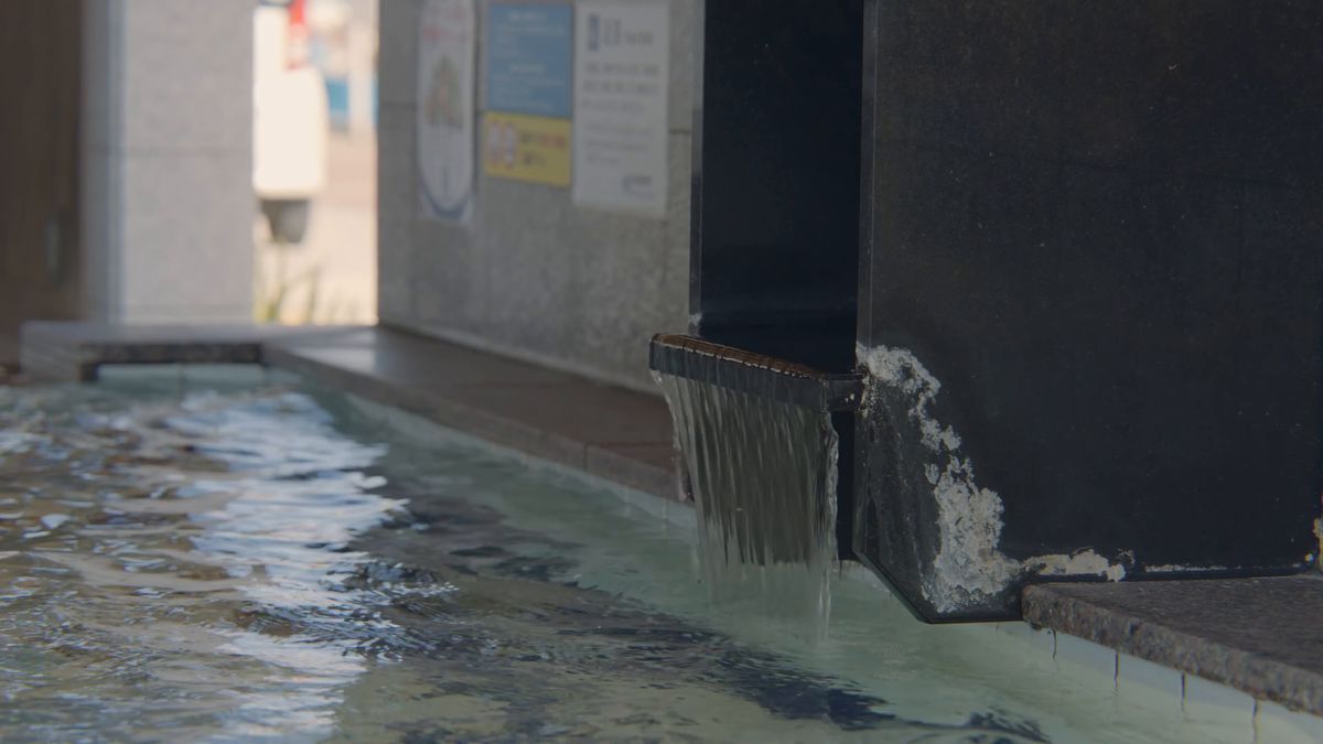 石のふちから湯が流れ込む足湯