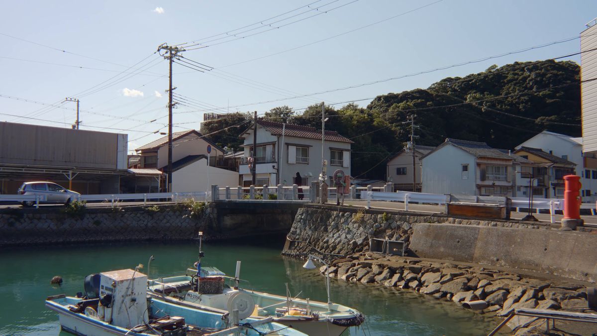 石積みの岸壁に並ぶ漁船と集落