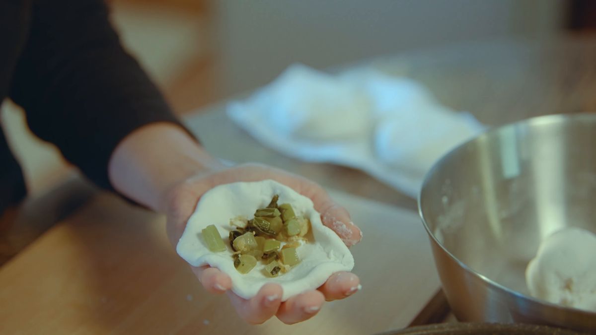 手のひらの生地に野沢菜の具をのせる