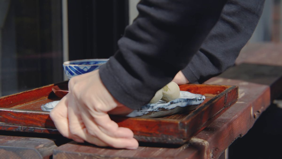 お盆の皿におやきをのせる手元
