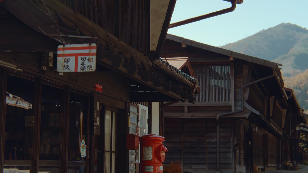 郵便の看板と赤いポストのある通り