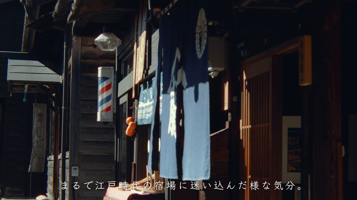 紺ののれんとサインポールの店先