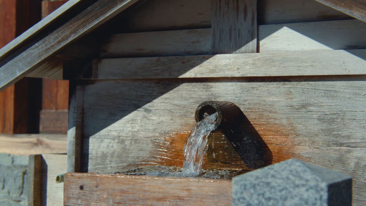 木の樋から水が流れ落ちる水場