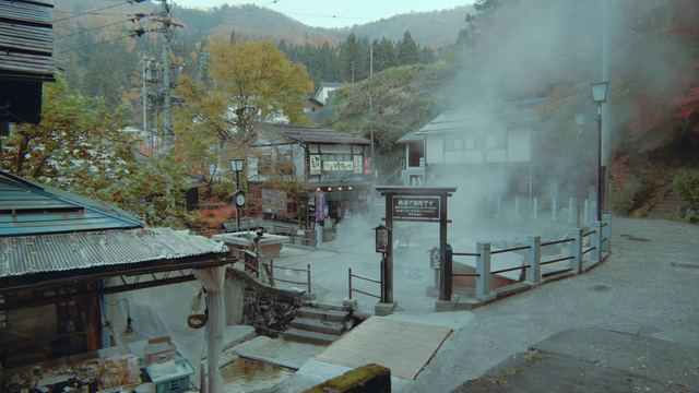 湯けむりの立つ麻釜と紅葉の温泉街