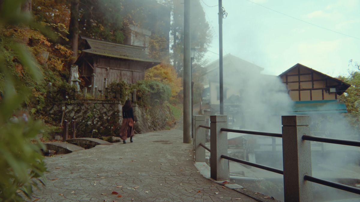 石垣の坂道を上る後ろ姿と紅葉