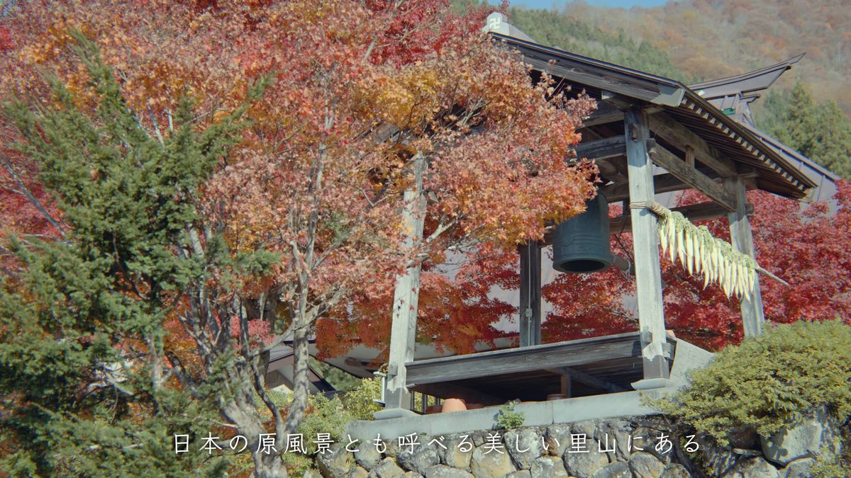 紅葉の中の鐘楼と、つるして干した白い野菜