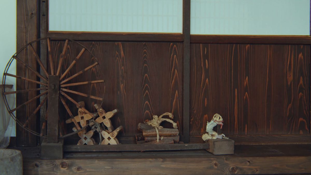 板壁の前の糸車とわら細工