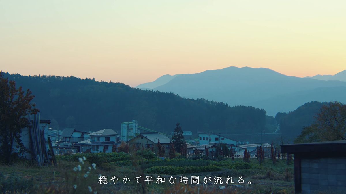 夕焼けに染まる山並みと村