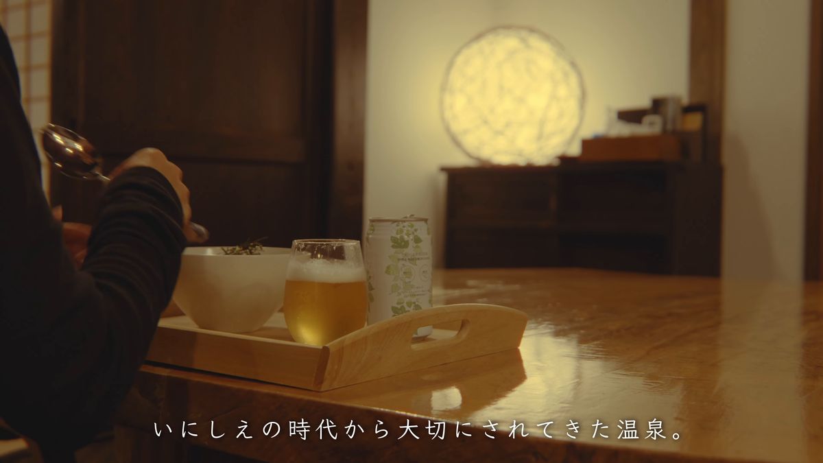 丸い照明の灯る座敷の卓に置いた盆とグラス