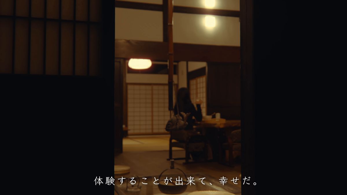 暗い座敷で食事をする後ろ姿