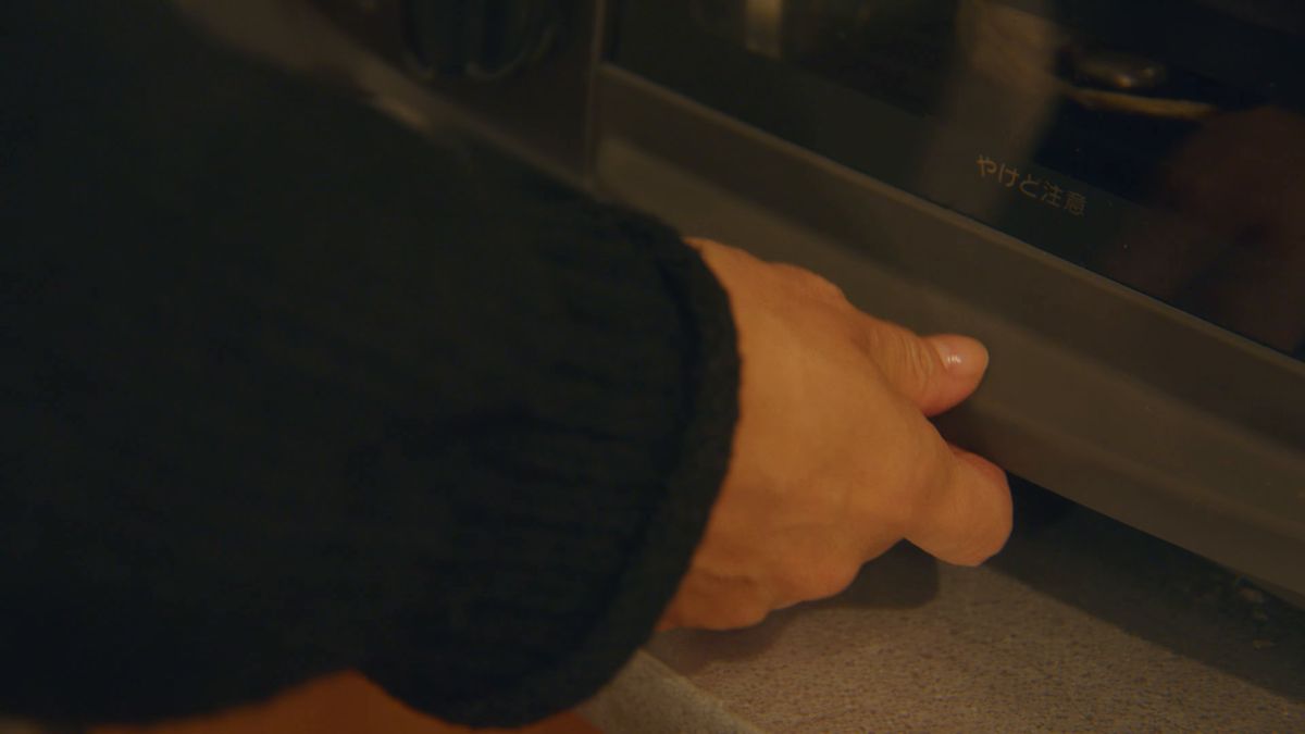グリルの扉を引く手元