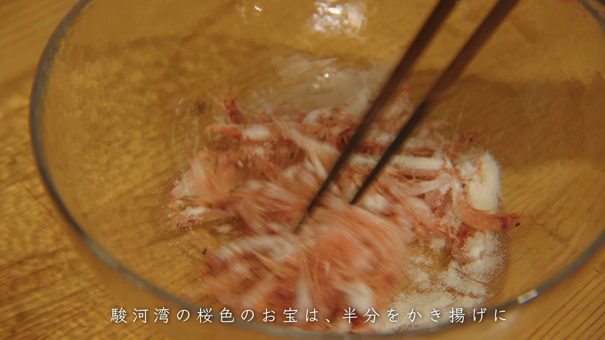 ガラスのボウルの生桜えびと衣を箸で混ぜる