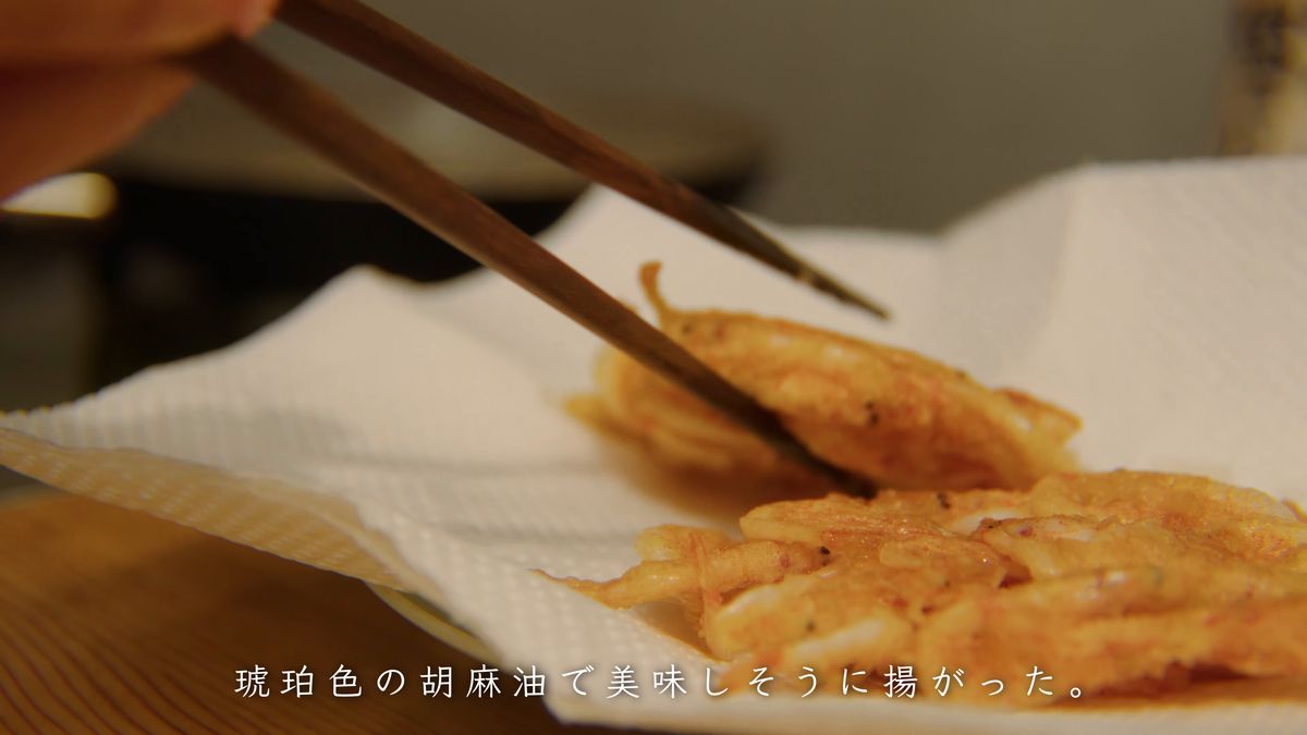 箸で持ち上げる揚げたての桜えびのかき揚げ