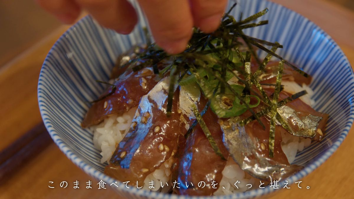アジの上に刻み海苔と青ねぎをのせる手元
