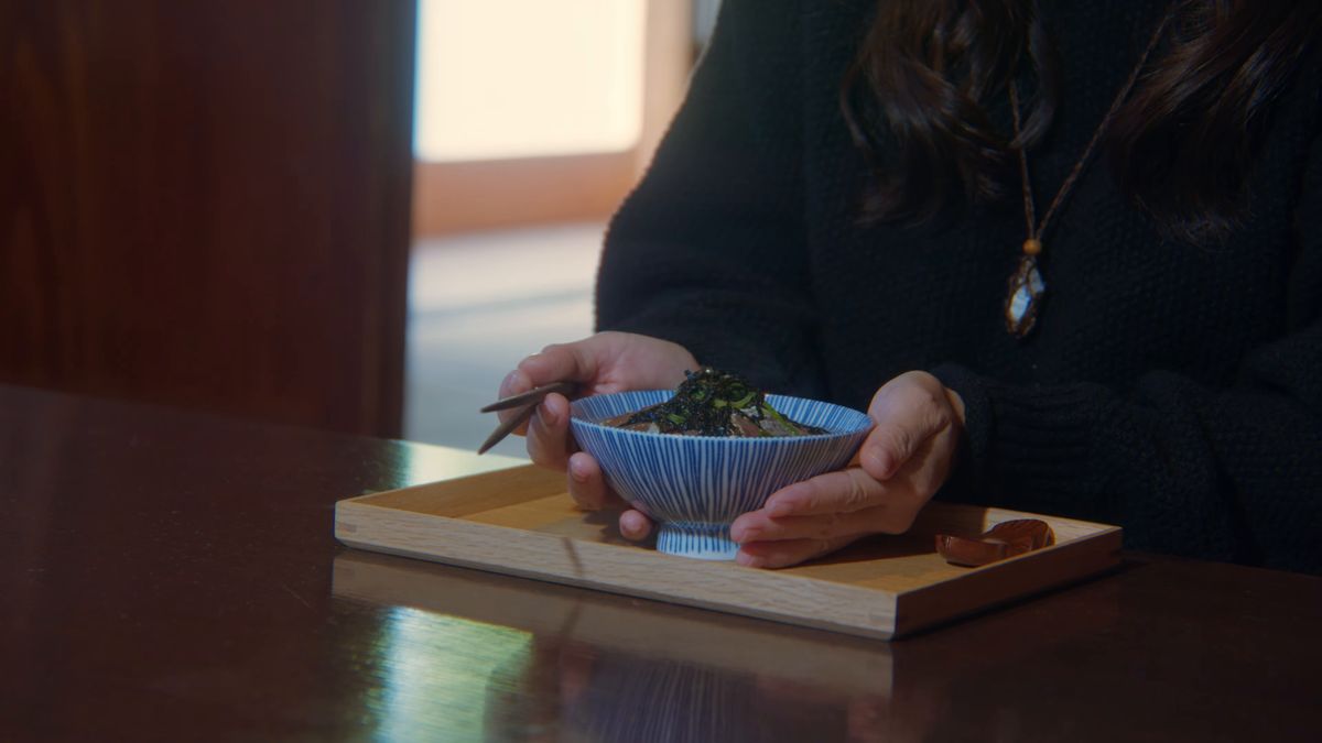 盆の上の茶漬けの茶碗に手を添える