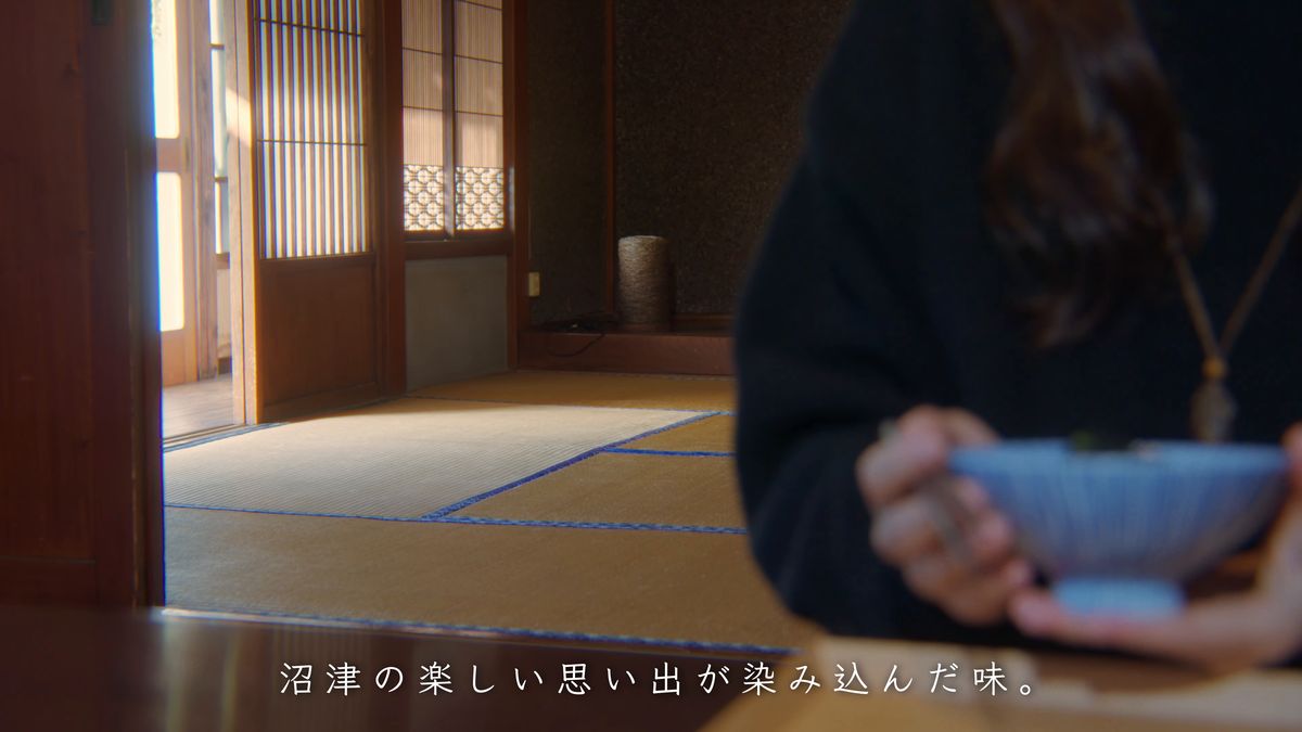 畳の間で茶碗を抱えて食べる後ろ姿