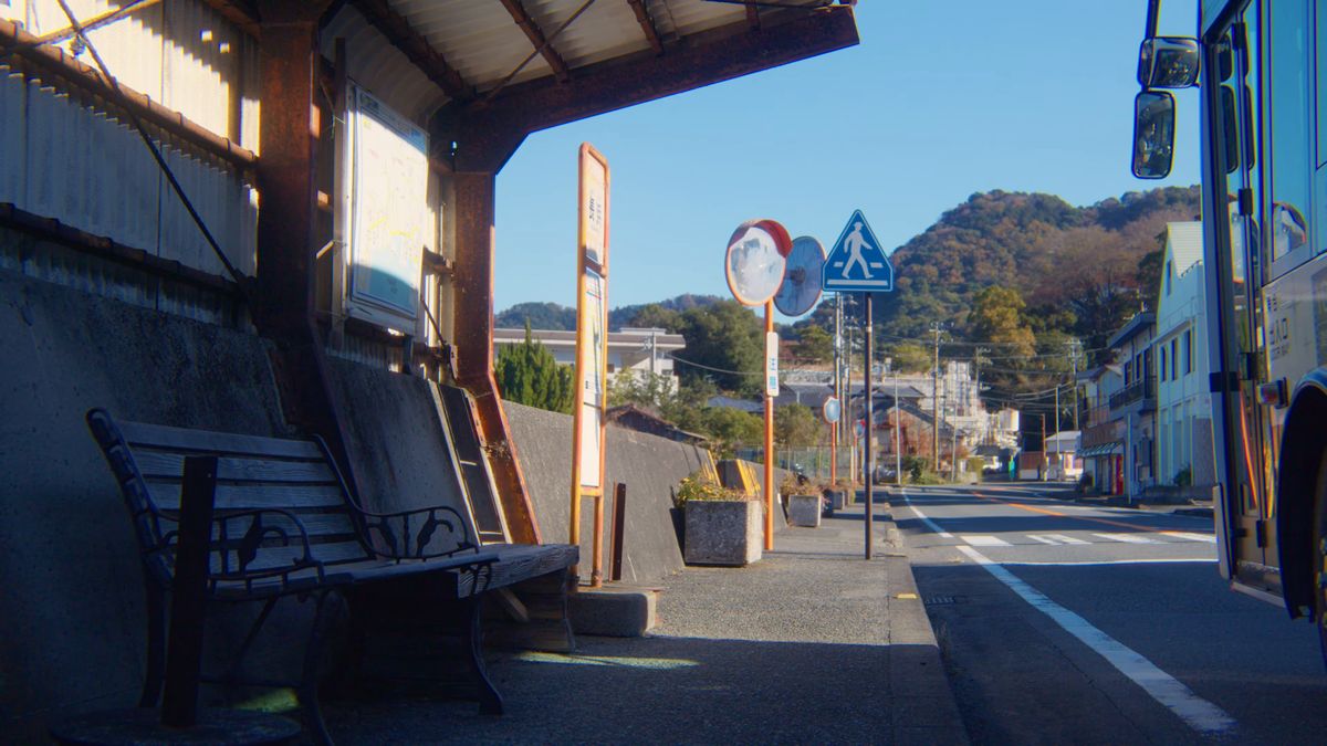 バス停のベンチと海辺の道、カーブミラー