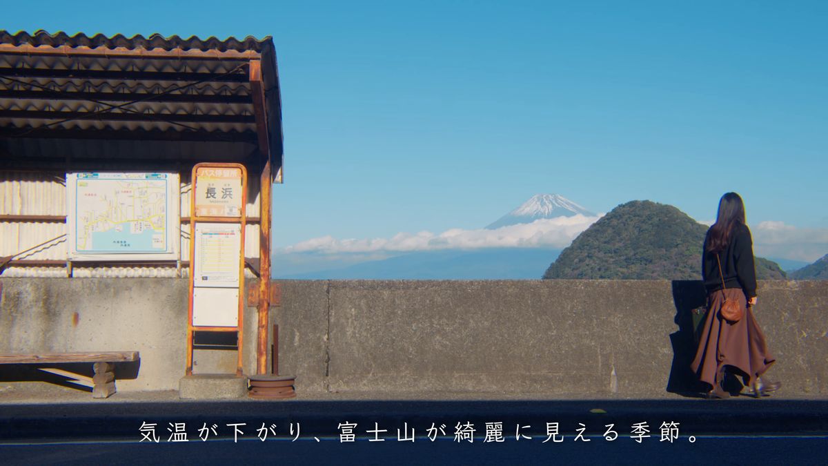 「長浜」のバス停からトランクを提げて歩き出す後ろ姿