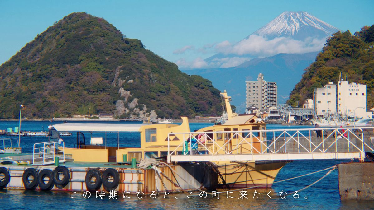 港に停まる黄色い船と、山並みの向こうの富士山
