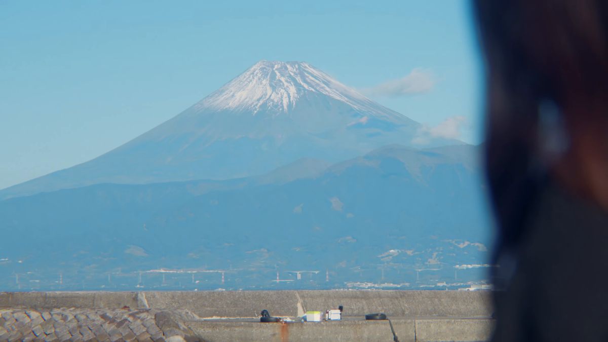 髪越しに見える雪をかぶった富士山