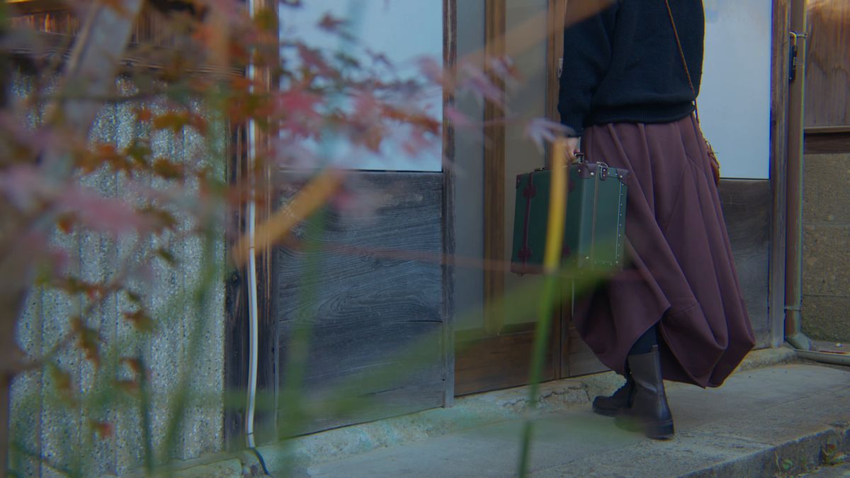木の葉越しに、玄関へ向かう後ろ姿