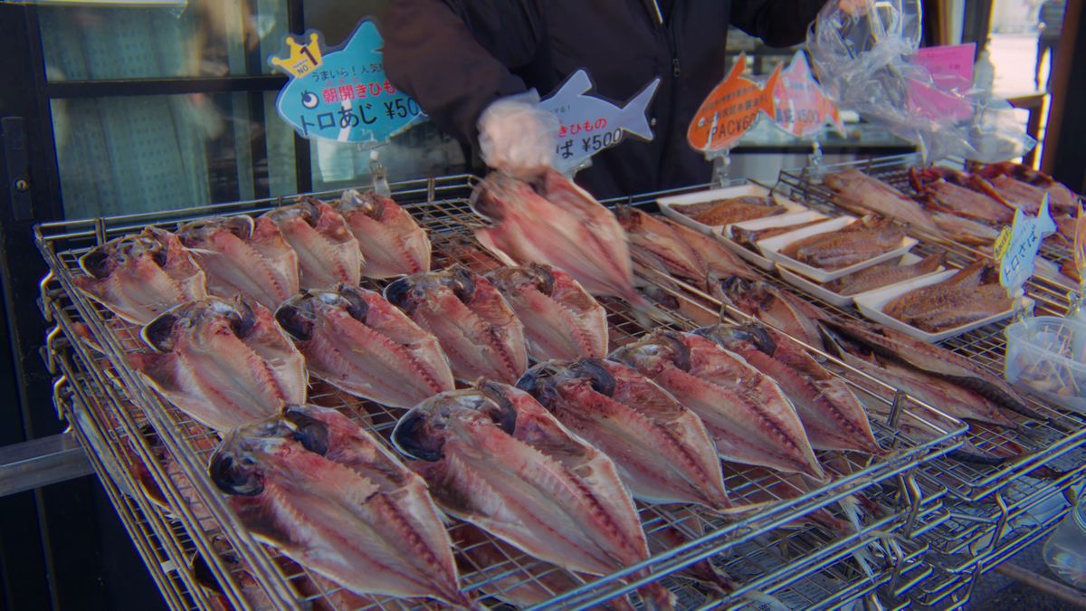 店先の台に並ぶアジの干物と魚の形の値札