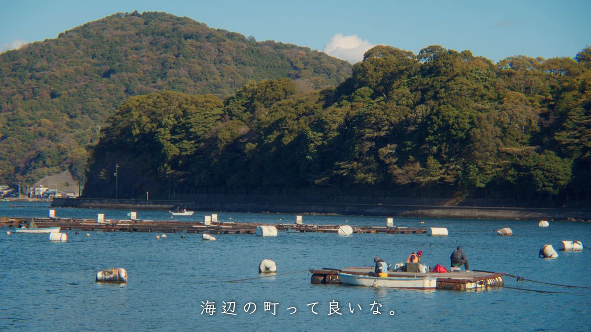 養殖いかだの浮かぶ内浦の海と小舟、緑の山