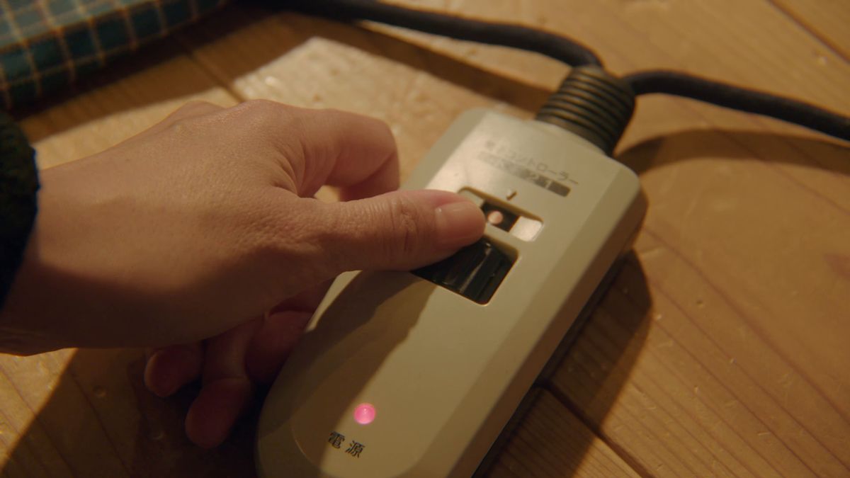 こたつのコントローラーのスイッチを入れる手元