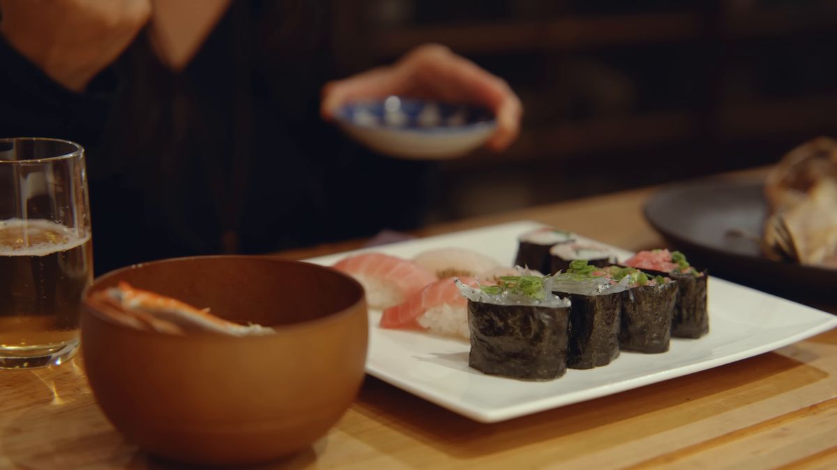 小皿を手にした食卓の寿司と椀